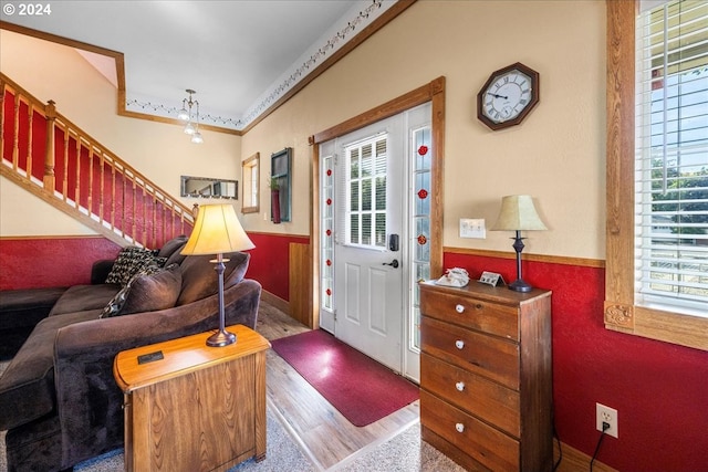 foyer entrance with a healthy amount of sunlight, wood finished floors, and wainscoting