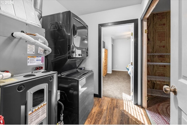 washroom featuring dark wood-style floors, laundry area, baseboards, and stacked washer / drying machine