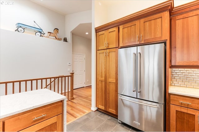 626 SE 38th Dr, Gresham, OR 97080 - kitchen with high quality fridge, backsplash, brown cabinets, light stone countertops, and recessed lighting