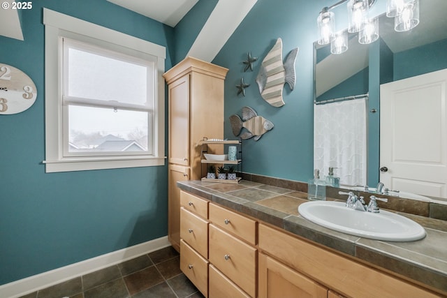 full bath with vanity, tile patterned floors, and baseboards
