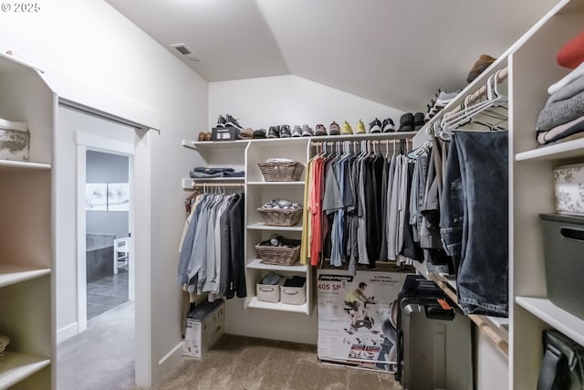 spacious closet with vaulted ceiling, carpet, and visible vents