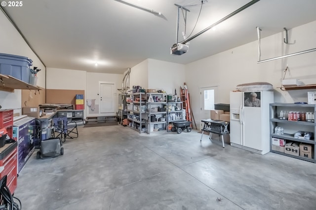 garage with a garage door opener and white fridge with ice dispenser