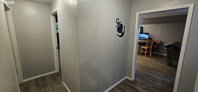 94191 Seaview Ln, Gold Beach, OR 97444 - hallway featuring dark wood-type flooring, a textured wall, baseboards, and an office area