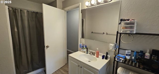 94191 Seaview Ln, Gold Beach, OR 97444 - full bath with wood finished floors, vanity, a shower with shower curtain, and a textured wall