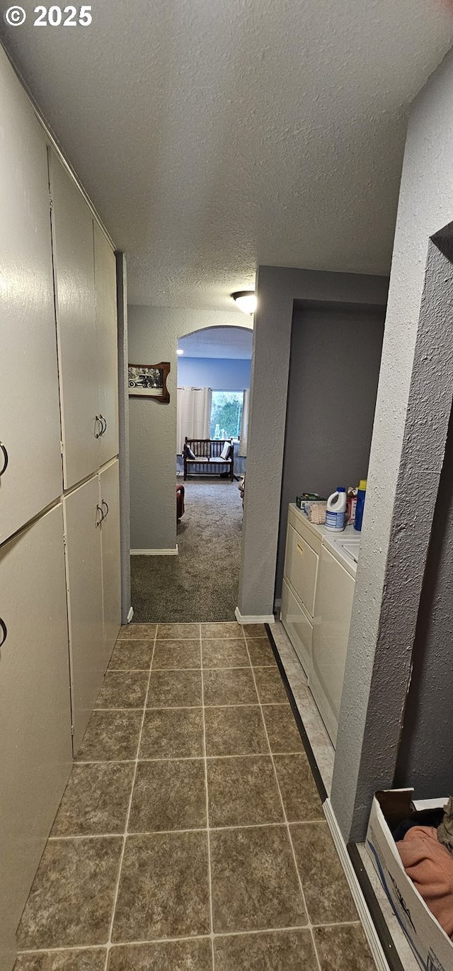 94191 Seaview Ln, Gold Beach, OR 97444 - corridor with washer and dryer, a textured ceiling, a textured wall, and baseboards