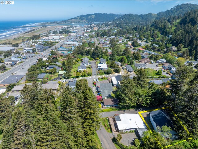 94191 Seaview Ln, Gold Beach, OR 97444 - aerial view of property and surrounding area featuring a mountain backdrop, property parcel outlined, and nearby suburban area