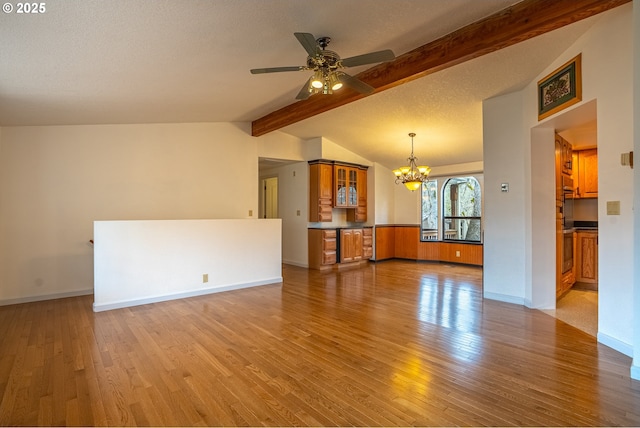 unfurnished living room with vaulted ceiling with beams, ceiling fan with notable chandelier, light hardwood / wood-style flooring, and a textured ceiling