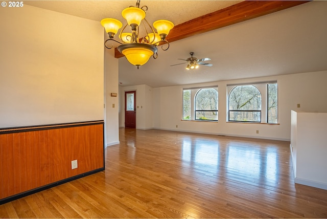 spare room with beamed ceiling, ceiling fan with notable chandelier, and light wood-type flooring