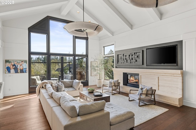 5390 NW Roanoke Ln, Portland, OR 97229 - living area featuring a glass covered fireplace, wood finished floors, beam ceiling, and high vaulted ceiling