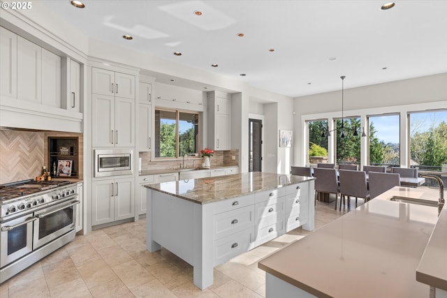 5390 NW Roanoke Ln, Portland, OR 97229 - kitchen featuring stainless steel appliances, a kitchen island, tasteful backsplash, plenty of natural light, and recessed lighting
