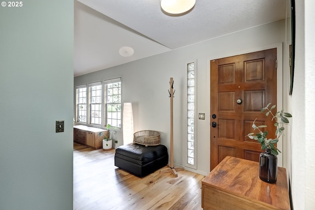 foyer with light wood-type flooring and baseboards