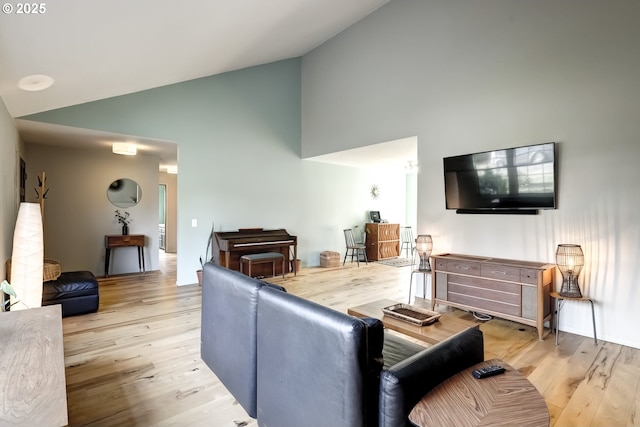 living room with high vaulted ceiling and wood finished floors