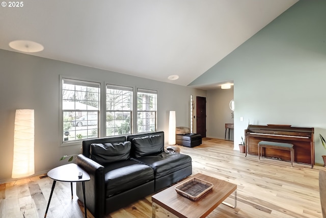 living room with high vaulted ceiling and light wood-style floors