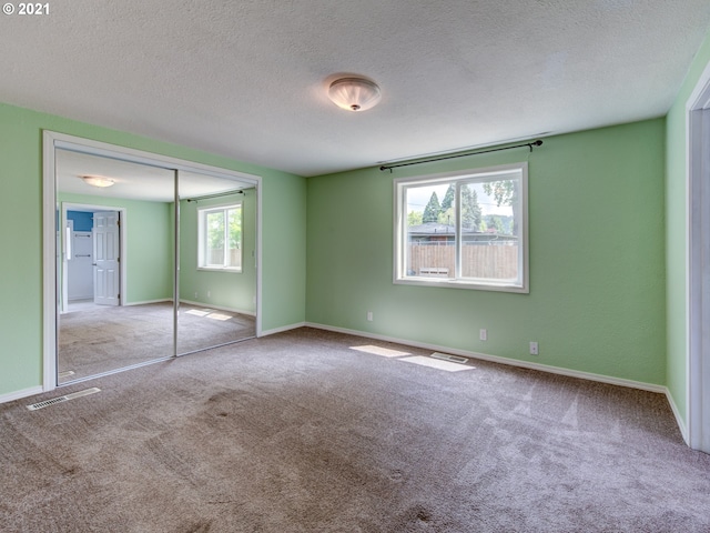 unfurnished bedroom featuring baseboards, a closet, visible vents, and light colored carpet