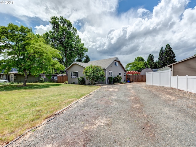 view of front of house with driveway, fence private yard, and a front yard