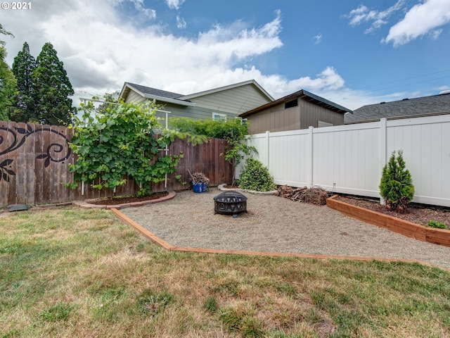 view of yard featuring an outdoor fire pit and a fenced backyard