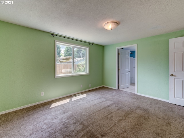 unfurnished bedroom with a textured ceiling, a textured wall, and light colored carpet