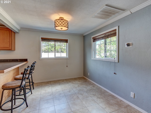 unfurnished dining area featuring visible vents, a wealth of natural light, and ornamental molding