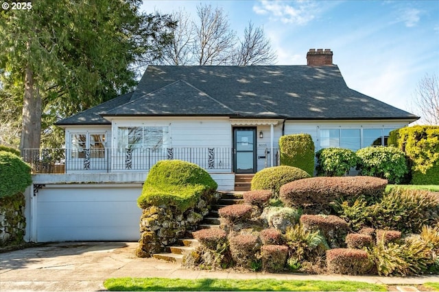 view of front of house featuring a garage, concrete driveway, and a chimney