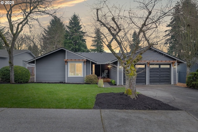 ranch-style house featuring a front lawn, a garage, driveway, and a shingled roof