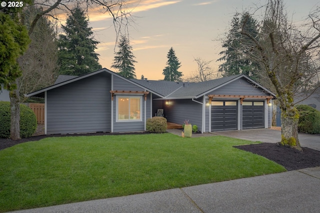 view of front of home featuring a lawn, concrete driveway, and a garage