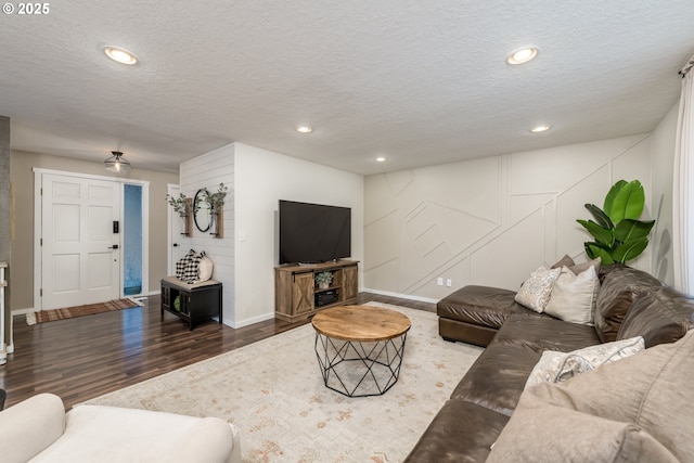 living room featuring dark wood finished floors, recessed lighting, and a textured ceiling