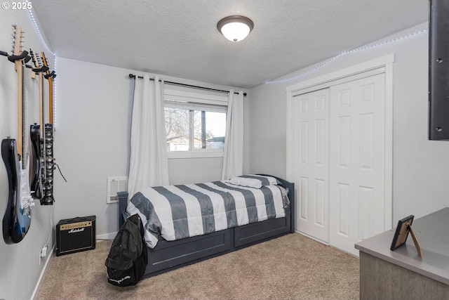 carpeted bedroom with a closet and a textured ceiling