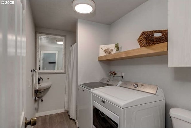 laundry room featuring wood-type flooring, sink, and washing machine and clothes dryer