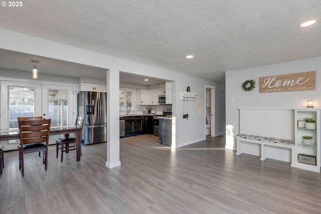 living room featuring french doors, light hardwood / wood-style floors, and a textured ceiling