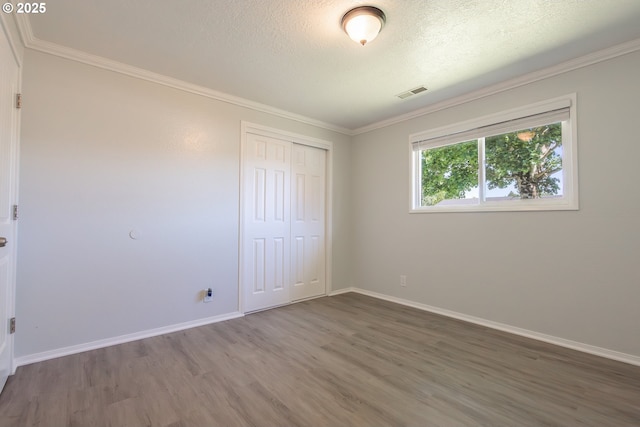 4738 NE Royal Oak Ct, Salem, OR 97301 - unfurnished bedroom with wood finished floors, a closet, baseboards, a textured ceiling, and ornamental molding