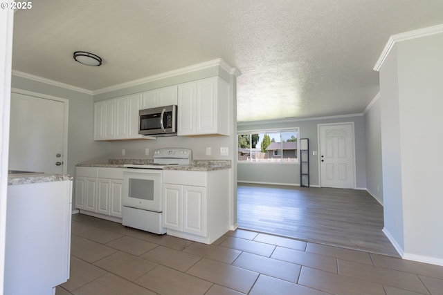 4738 NE Royal Oak Ct, Salem, OR 97301 - kitchen featuring white electric stove, stainless steel microwave, crown molding, white cabinets, and baseboards