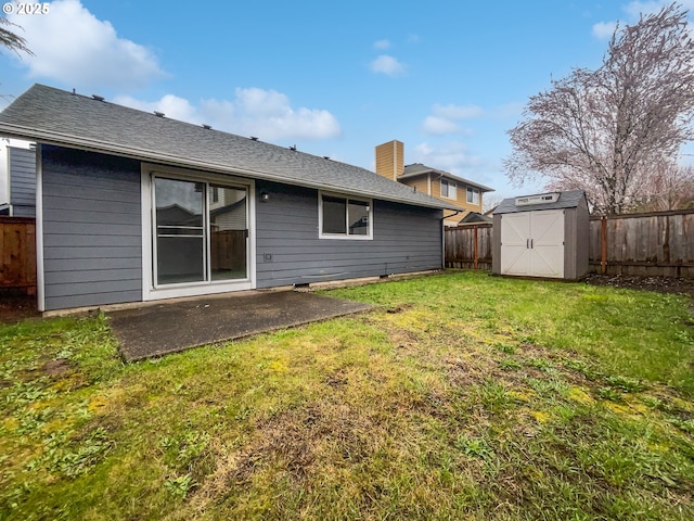 rear view of property featuring a storage unit, an outbuilding, a lawn, a patio, and a fenced backyard