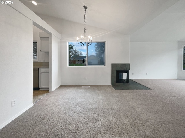 unfurnished living room featuring a multi sided fireplace, carpet flooring, a notable chandelier, and vaulted ceiling