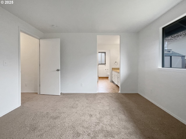 spare room with baseboards and carpet