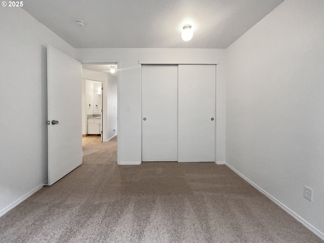 unfurnished bedroom featuring a closet, carpet flooring, and baseboards