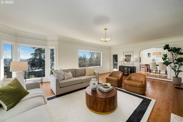 2869 SW Champlain Dr, Portland, OR 97205 - living area featuring wood finished floors, arched walkways, and crown molding