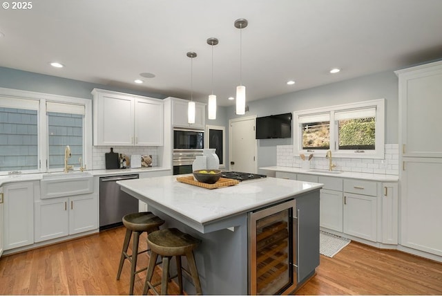 2869 SW Champlain Dr, Portland, OR 97205 - kitchen featuring beverage cooler, stainless steel appliances, tasteful backsplash, white cabinets, and recessed lighting