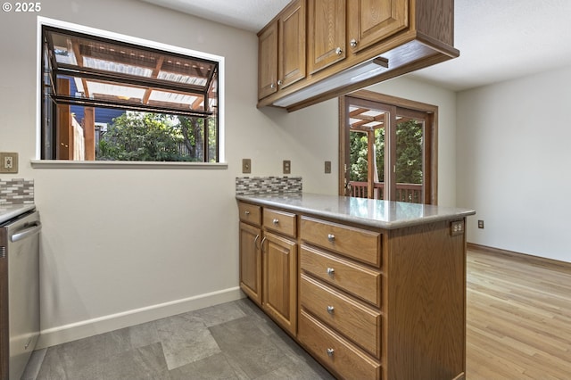 11118 SW 51st Ave, Portland, OR 97219 - kitchen with stainless steel dishwasher, a peninsula, brown cabinets, and light countertops