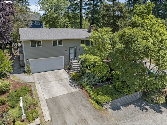 11118 SW 51st Ave, Portland, OR 97219 - raised ranch featuring a garage, driveway, a chimney, and a shingled roof