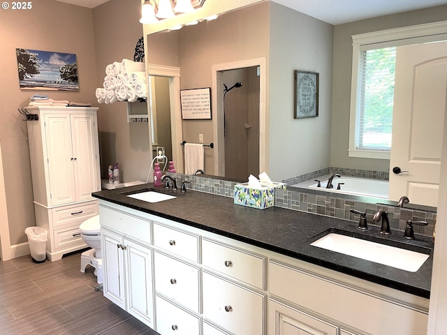 bathroom featuring double vanity, a sink, walk in shower, and a bath