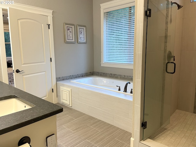 bathroom featuring vanity, a bath, and a stall shower