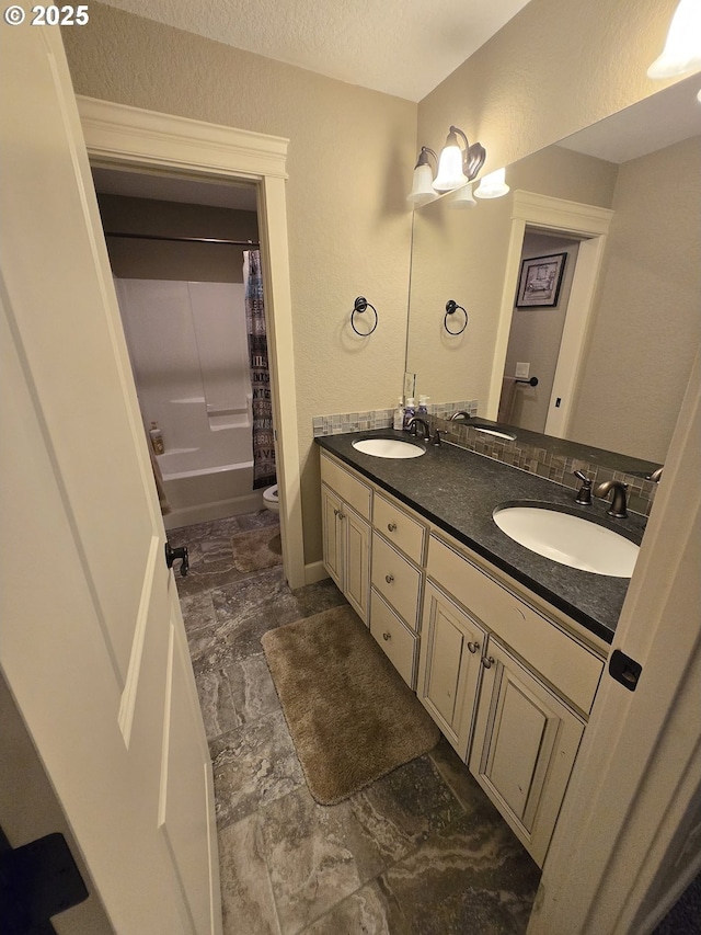 bathroom featuring double vanity, toilet, and a sink