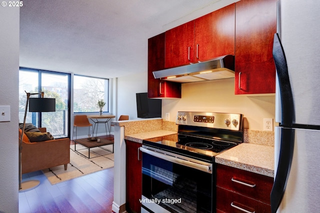 kitchen with hardwood / wood-style flooring, refrigerator, and stainless steel range with electric cooktop