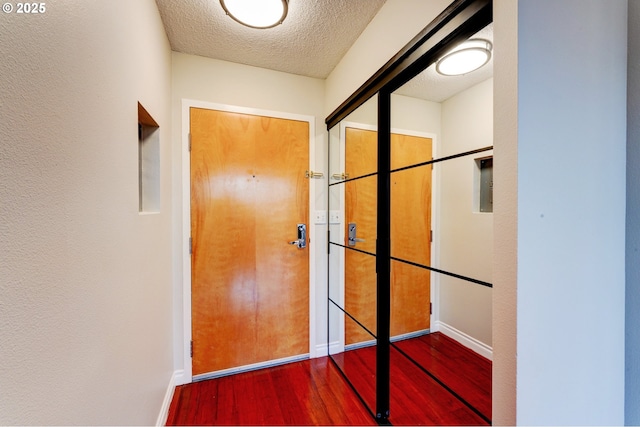 doorway to outside featuring a textured ceiling and wood-type flooring