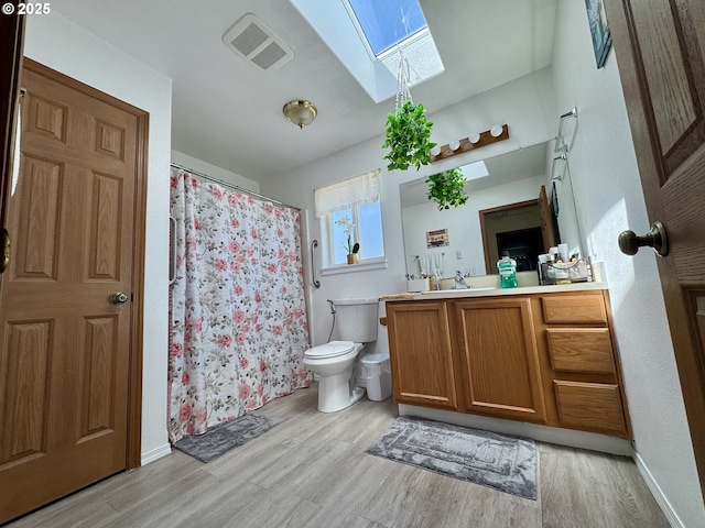 3125 NE Flintlock Pl, Corvallis, OR 97330 - full bath featuring a skylight, wood finished floors, toilet, vanity, and a shower with shower curtain