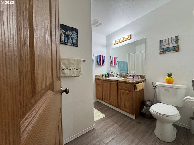 3125 NE Flintlock Pl, Corvallis, OR 97330 - bathroom with wood finished floors, toilet, vanity, and baseboards