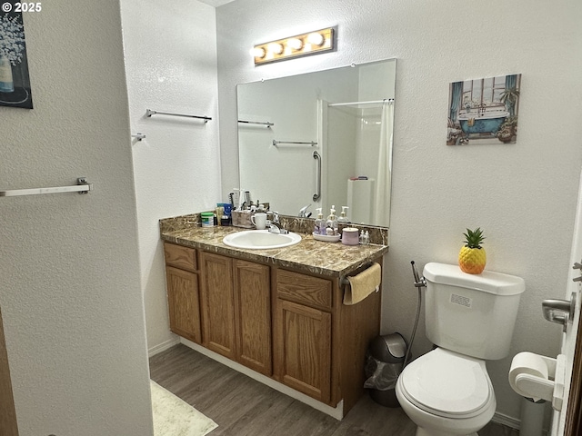 3125 NE Flintlock Pl, Corvallis, OR 97330 - bathroom with wood finished floors, toilet, a shower, and a textured wall