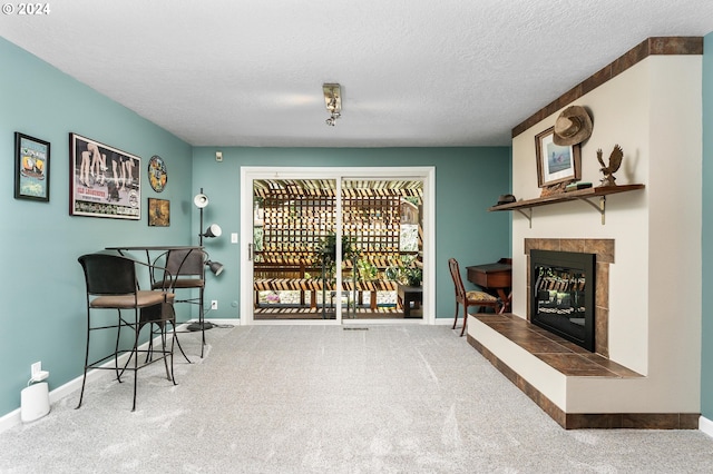 wine room with carpet floors, baseboards, a textured ceiling, and a tile fireplace