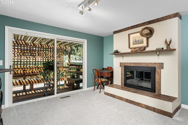 wine area featuring a textured ceiling, a fireplace, carpet flooring, visible vents, and baseboards