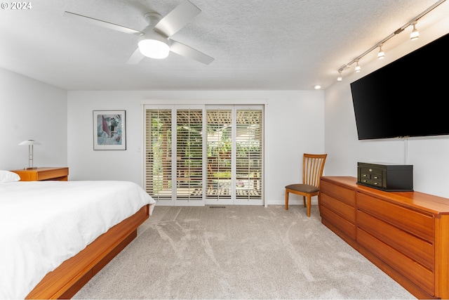 carpeted bedroom featuring a textured ceiling, access to outside, ceiling fan, and track lighting